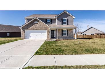 Two-story home with brick and gray siding, a two-car garage, and a well-manicured front lawn at 6559 Ambrosia Ln, Pendleton, IN 46064
