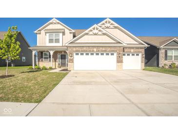 Inviting two-story home with brick accents and a spacious three-car garage and a manicured lawn at 657 Kilmore Dr, Pendleton, IN 46064
