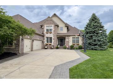 Beautiful brick home featuring a three-car garage, well-manicured lawn, and tasteful landscaping at 1014 Massey Ct, Greenwood, IN 46143