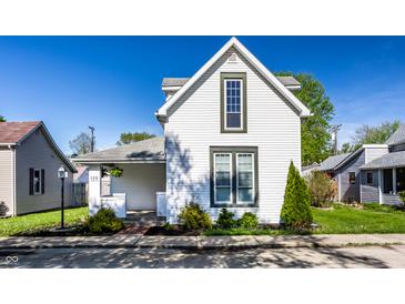Charming two-story home featuring white siding, well-manicured lawn, and an inviting front garden at 139 N East St, Pendleton, IN 46064