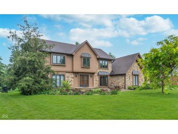 Charming two-story home with a combination of stone and siding exterior and well-maintained landscaping at 1421 Stoney Creek Cir, Carmel, IN 46032