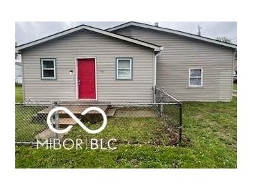 Charming single-story home features a red door and fenced front yard at 1710 S Birch St, Muncie, IN 47302