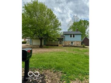 Charming home with two-tone siding, stone accents, covered porch, and lush green front yard at 1945 Plantation Ln, Martinsville, IN 46151