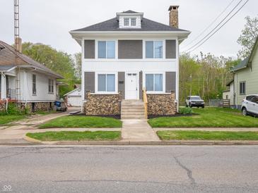 Charming two-story home featuring a stone facade, gray siding, and a well-manicured front lawn at 204 N Vine St, Shelbyville, IN 46176