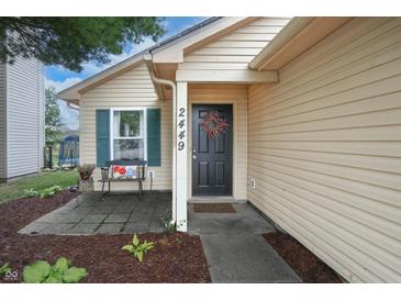 Inviting home exterior with a black front door, wreath, bench and well-maintained landscaping at 2449 Orchard Creek Dr, Columbus, IN 47201