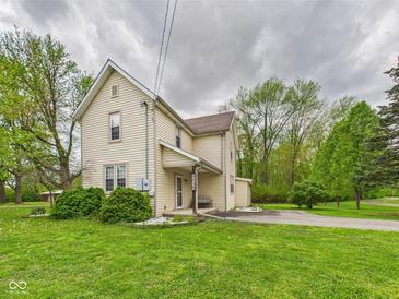 Charming two-story home with yellow siding, a covered porch, and a well-maintained lawn at 4079 S 50 W, Anderson, IN 46013