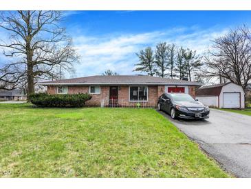 Charming brick home with a well-manicured lawn and attached garage, offering classic curb appeal at 5027 E 40Th St, Indianapolis, IN 46226