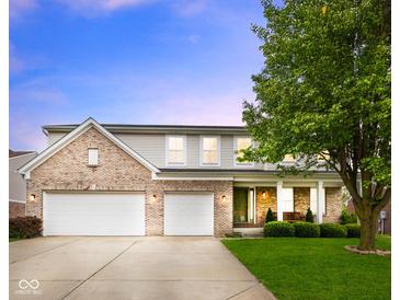 Charming two-story brick home featuring a spacious three-car garage and manicured lawn at 5851 Grand Ave, Plainfield, IN 46168