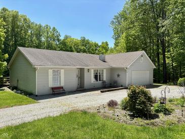 Charming single-story home with light gray siding and mature trees in a peaceful setting at 8310 Goat Hollow Rd, Martinsville, IN 46151