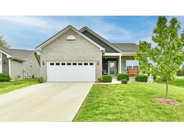 Charming brick home featuring a two-car garage, a manicured lawn, and a cozy front porch at 998 Cass Dr, Franklin, IN 46131