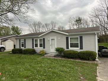 Charming one-story home with manicured lawn and classic curb appeal on an overcast day at 117 Fountain Lake Dr, Greenfield, IN 46140