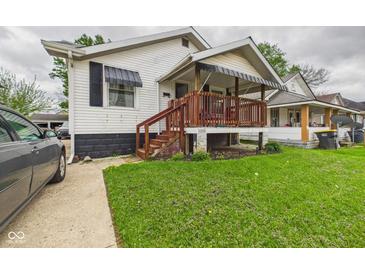 Charming home featuring a covered front porch with wooden railings and a well-maintained lawn at 2314 Walnut St, Anderson, IN 46016