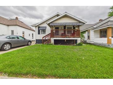 Quaint home with inviting covered porch, complemented by lush green lawn and mature landscaping at 2314 Walnut St, Anderson, IN 46016
