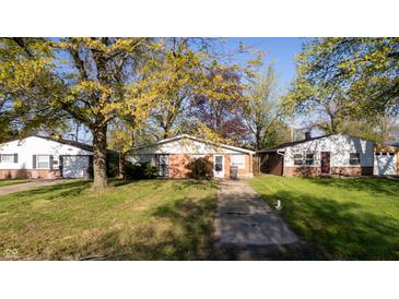 A well kept front yard with ranch style houses on a sunny day at 268 S Grant Ave, Indianapolis, IN 46201