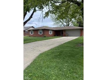 Charming brick ranch home with a well-maintained lawn and an attached two-car garage at 2935 Flintwood Dr, Columbus, IN 47203