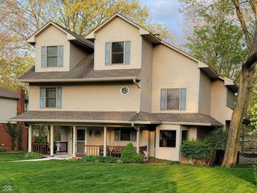 Charming two-story home with light tan siding, blue shutters, covered porch, and a well-manicured lawn at 448 Tamarack Ln, Noblesville, IN 46062