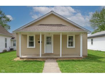 Charming single-story home with neutral siding, front porch and well-maintained lawn at 52 N Ross St, Columbus, IN 47201