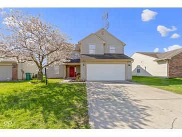 Charming two-story home with a two-car garage, blossoming tree, and well-maintained lawn at 7907 Oakdale Ln, Indianapolis, IN 46214
