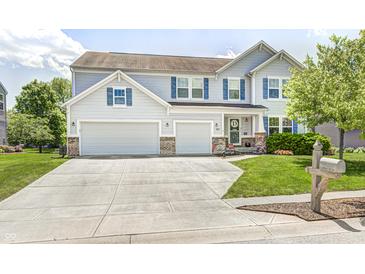 Charming two-story home with a well-manicured lawn, two-car garage, and a welcoming front entrance at 11121 Godfrey Dr, Noblesville, IN 46060