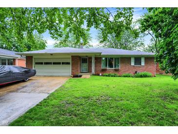 Charming brick ranch home featuring a well-manicured lawn and an attached two-car garage at 1225 N Graham Ave, Indianapolis, IN 46219