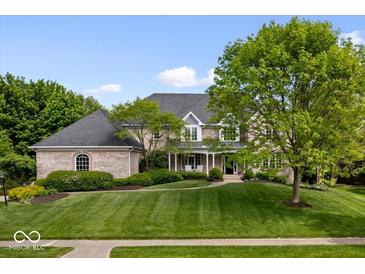 Beautiful brick home with a manicured lawn and lush landscaping at 12399 Lynnwood Blvd, Carmel, IN 46033