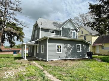 Charming two-story home with gray siding and white trim, surrounded by a green lawn at 1715 S Madison St, Muncie, IN 47302