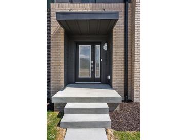 Stylish front door with glass panels, a covered entryway, and a modern brick facade create a welcoming entrance at 9891 Baneberry Ln, Carmel, IN 46290