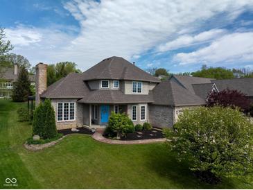 Beautiful home with a large front yard and a blue front door at 11780 Pebblepointe Pass, Carmel, IN 46033