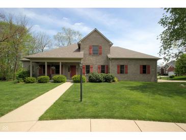 Charming brick home featuring a well-manicured lawn, red shutters, and a welcoming front porch at 17003 Whitebark Ct, Westfield, IN 46074