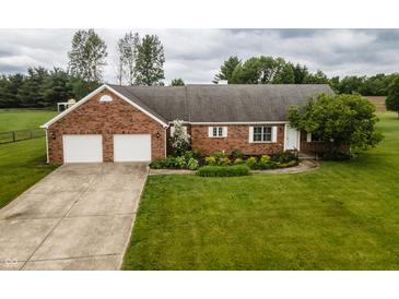 Charming brick home featuring an attached two-car garage and lush lawn at 2708 N Buck Creek Rd, Greenfield, IN 46140