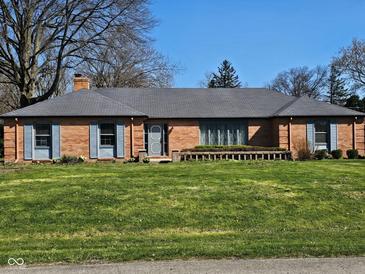Charming single story brick home featuring a well-manicured front lawn and an inviting entrance at 3128 W 12Th St, Anderson, IN 46011