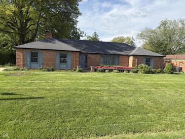 Charming brick home with a well-manicured lawn and flower beds at 3128 W 12Th St, Anderson, IN 46011