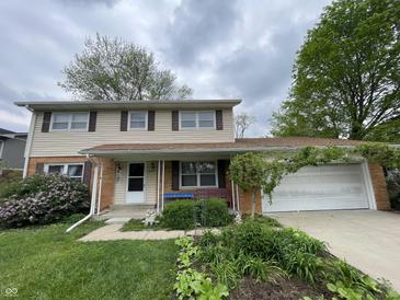 Charming two-story home with a well-maintained lawn, landscaping, and a cozy front porch area at 3232 St Jude Dr, Indianapolis, IN 46227