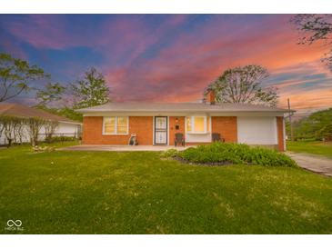 Charming red brick home featuring a well-manicured lawn and inviting front porch with seating at 3846 Alsace Pl, Indianapolis, IN 46226