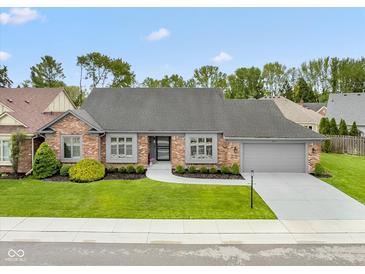 Charming brick home with manicured lawn and gray trim, showcasing classic curb appeal at 4711 Bentley Dr, Carmel, IN 46033