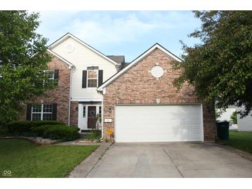 Charming two-story brick home with a two-car garage, a well-maintained lawn, and mature trees at 8551 Walden Trace Dr, Indianapolis, IN 46278