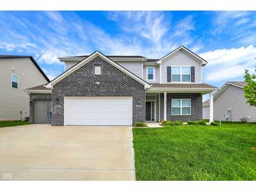 Charming two-story home featuring black brick and gray siding, well manicured lawn, and an attached two-car garage at 10236 Arctic Edge Dr, Indianapolis, IN 46239