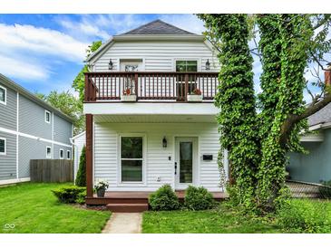 Charming two-story home featuring a balcony, manicured lawn, and tasteful landscaping at 1434 Laurel St, Indianapolis, IN 46203