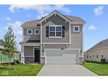Two-story home featuring a two-car garage, stone accents and gray siding at 1874 Victor Higgins Dr, Shelbyville, IN 46176