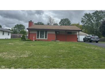 Charming single-story home with brick accents, attached garage, and lush green lawn at 211 Woodlane Dr, Columbus, IN 47201