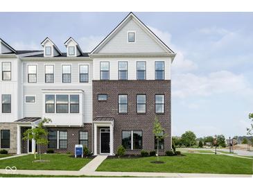 Charming townhouse with brick facade, a black front door, and well-manicured lawn and landscaping at 3279 Morab Dr, Zionsville, IN 46077