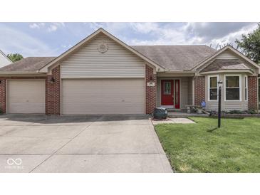 Charming home featuring a three-car garage, brick accents, and a vibrant red front door at 4675 Walker St, Greenwood, IN 46143