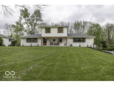 Charming two-story home featuring a manicured lawn, painted brick, and inviting front porch at 5137 Green Hills Dr, Brownsburg, IN 46112