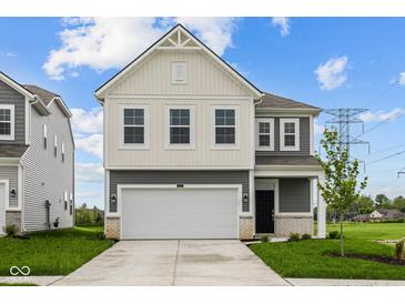 Charming two-story home with a two-car garage, black door, and nicely manicured lawn at 6219 Medina Spirit Dr, Indianapolis, IN 46237
