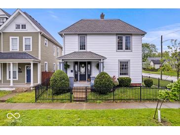Charming two-story home with a well-manicured front yard and a black wrought iron fence at 925 S State Ave, Indianapolis, IN 46203