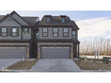 New two-story gray townhome with brick accents, garage, and a concrete driveway at 9767 Behner Dr, Fishers, IN 46250