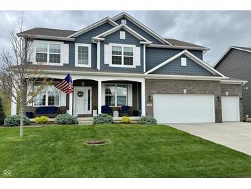 Charming two-story home with blue siding, brick accents, manicured lawn, and a welcoming front porch at 6309 Harvey Dr, Plainfield, IN 46168