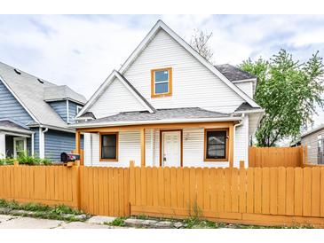 Charming two-story home with a bright yellow fence and inviting front porch at 647 Coffey St, Indianapolis, IN 46221