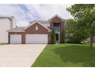 Charming two-story brick home with a well-manicured lawn, mature tree, and an attached two-car garage at 6839 Powder Dr, Indianapolis, IN 46259