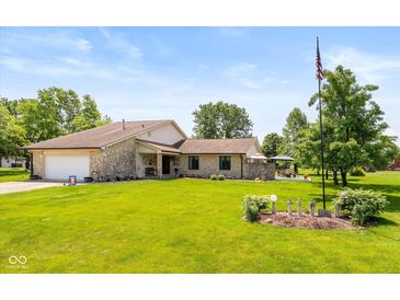 Charming stone home featuring a well-manicured lawn and a decorative American flag at 8111 Timberwood Dr, Plainfield, IN 46168